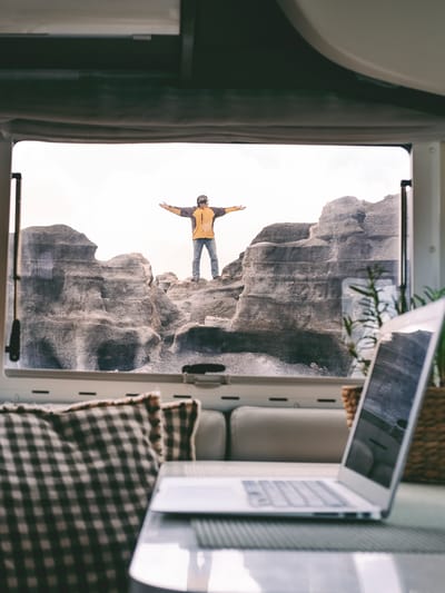 digital nomad standing outside his compact travel trailer similar to van life
